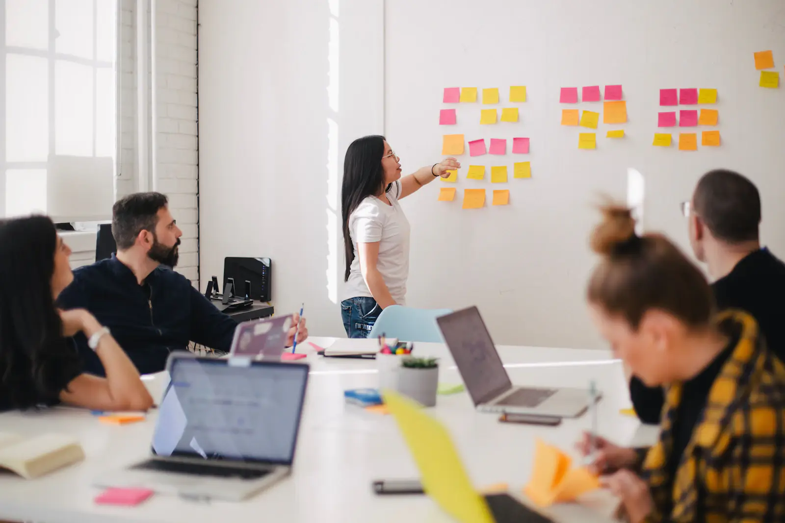 Pessoas organizando ideias com post-its numa parede
