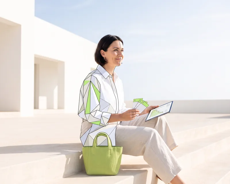 Founder sitting on the steps of a white building on a sunny morning, with her tablet showing the chart and the cards, half drawn in facets